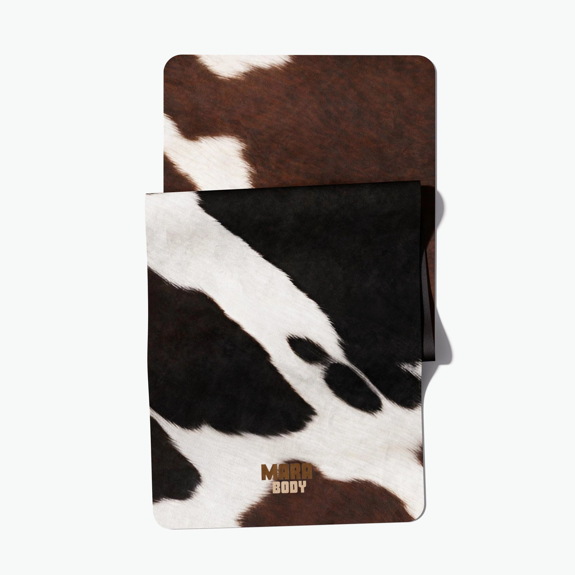 Cow print phone case with MARA BODY branding on a white background