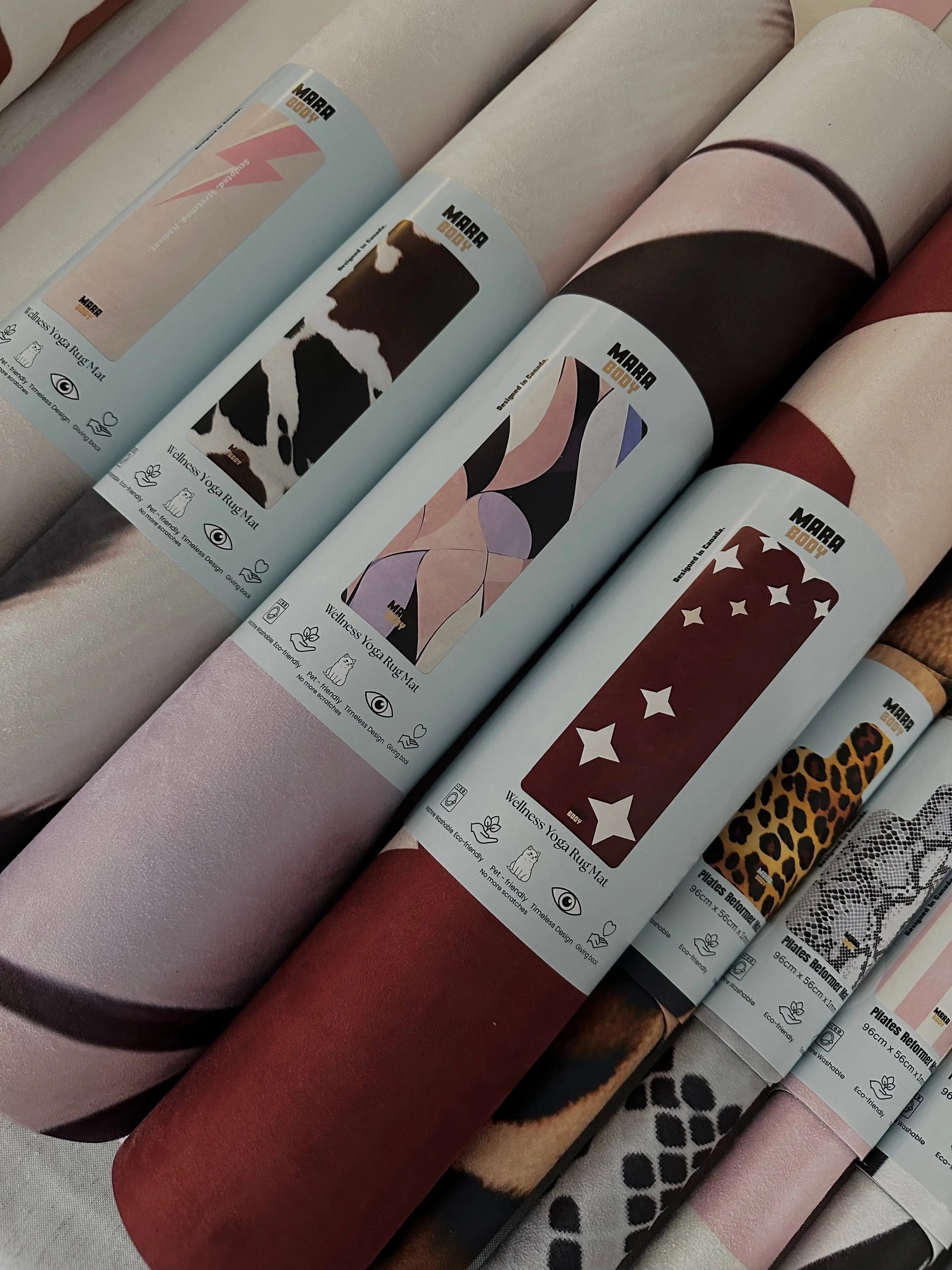 Collection of sustainable patterned yoga mats and reformer mats with visible brand labels MARA BODY