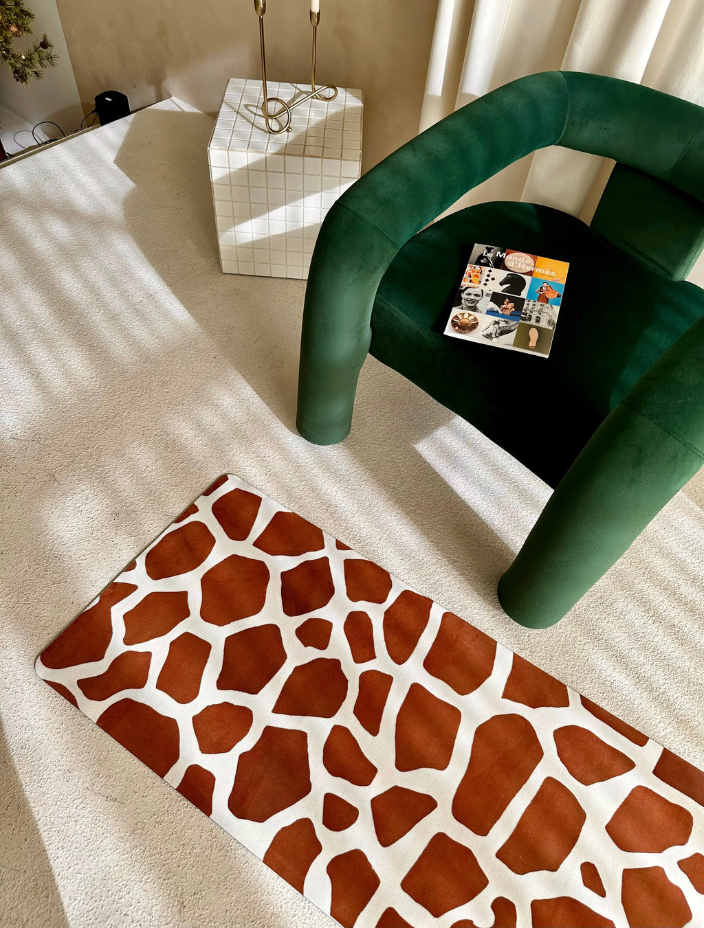Green chair with a animal print patterned yoga mat on a light-colored floor