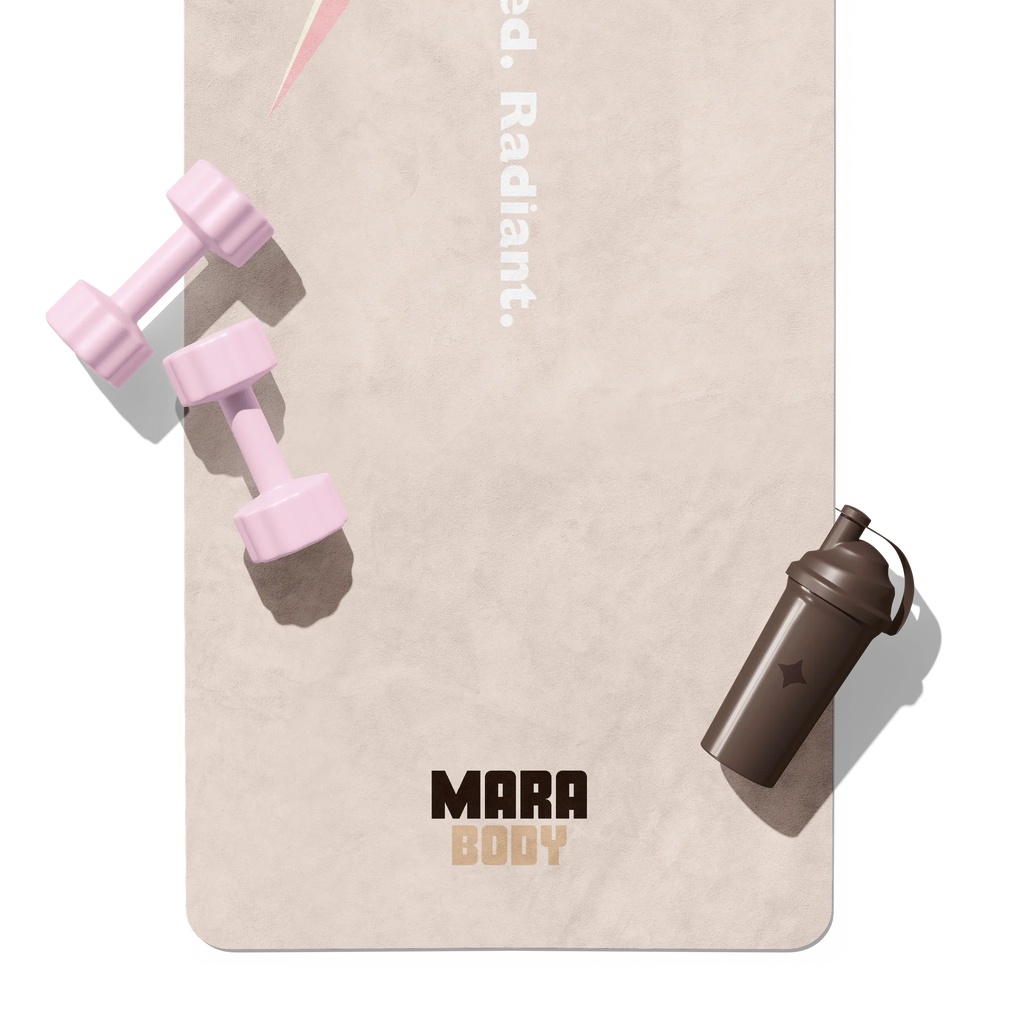 Pink dumbbells and a brown shaker bottle on a beige yoga mat with 'Mara Body' branding.