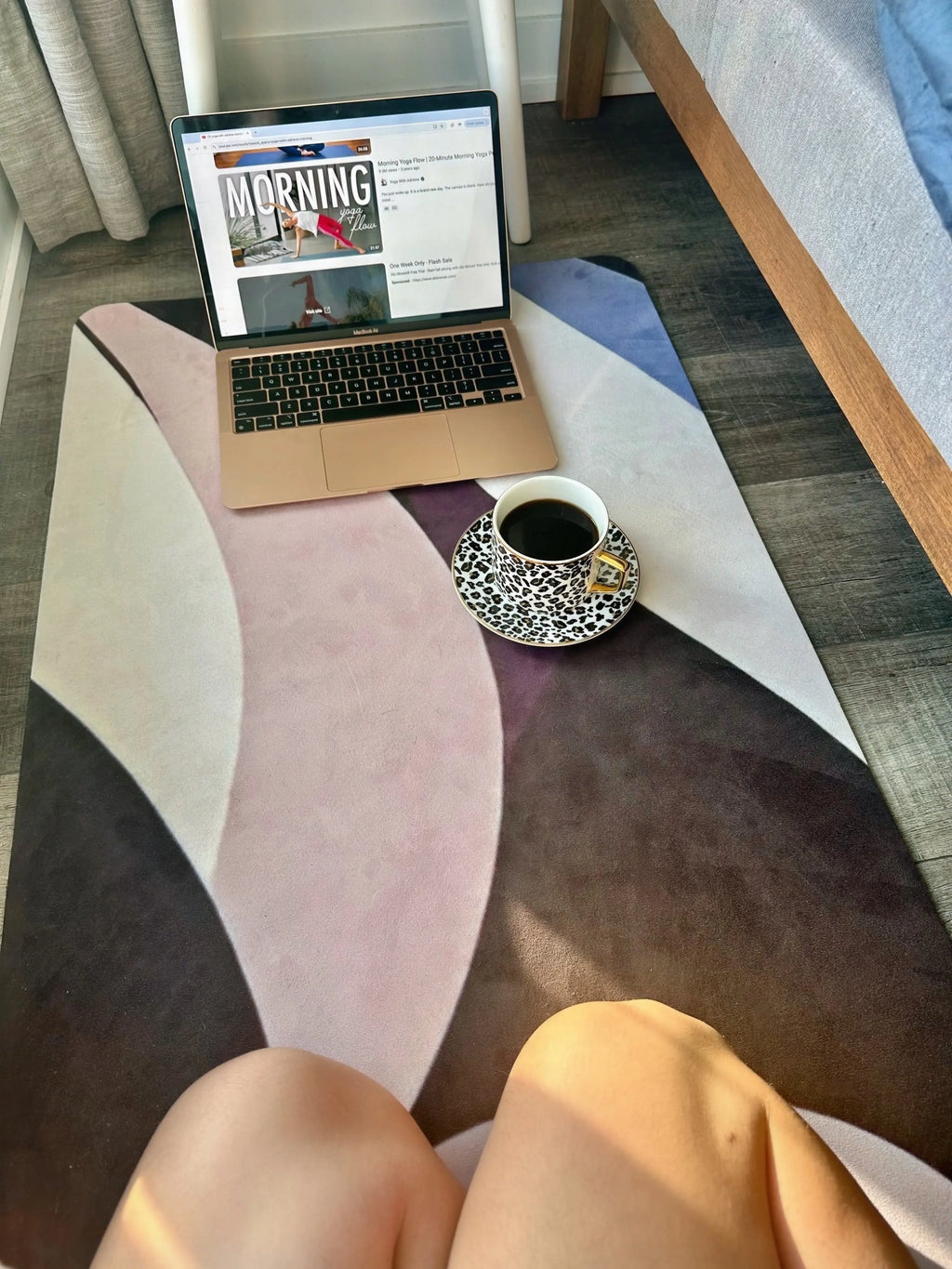 Laptop with morning yoga flow workout on a colorful designer yoga mat with a cup of coffee nearby, bedroom decor ideas