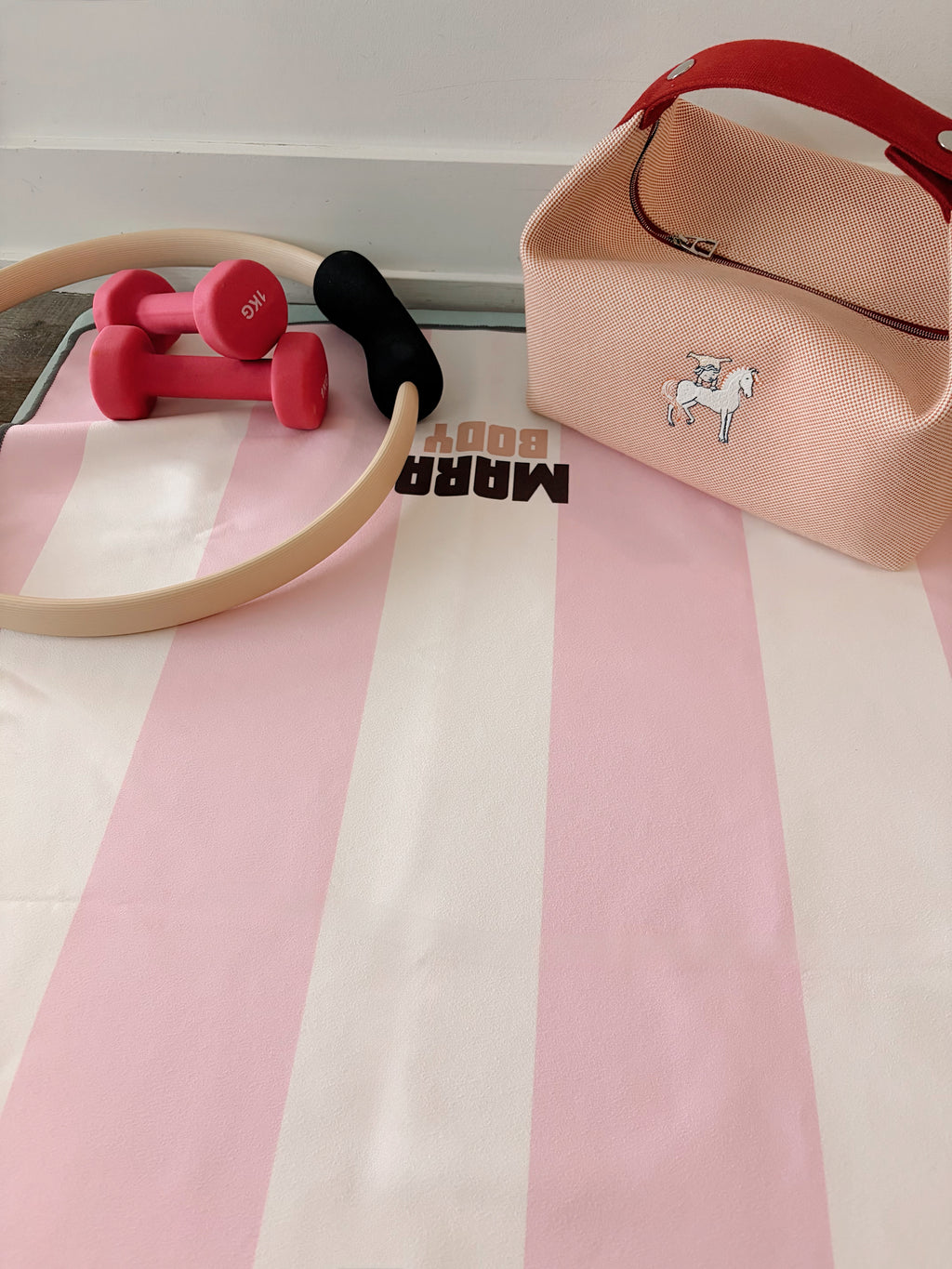 pink white striped yoga towel for hot yoga and yoga mat with pink dumbbells, pilates ring and hermes bride a brac bag