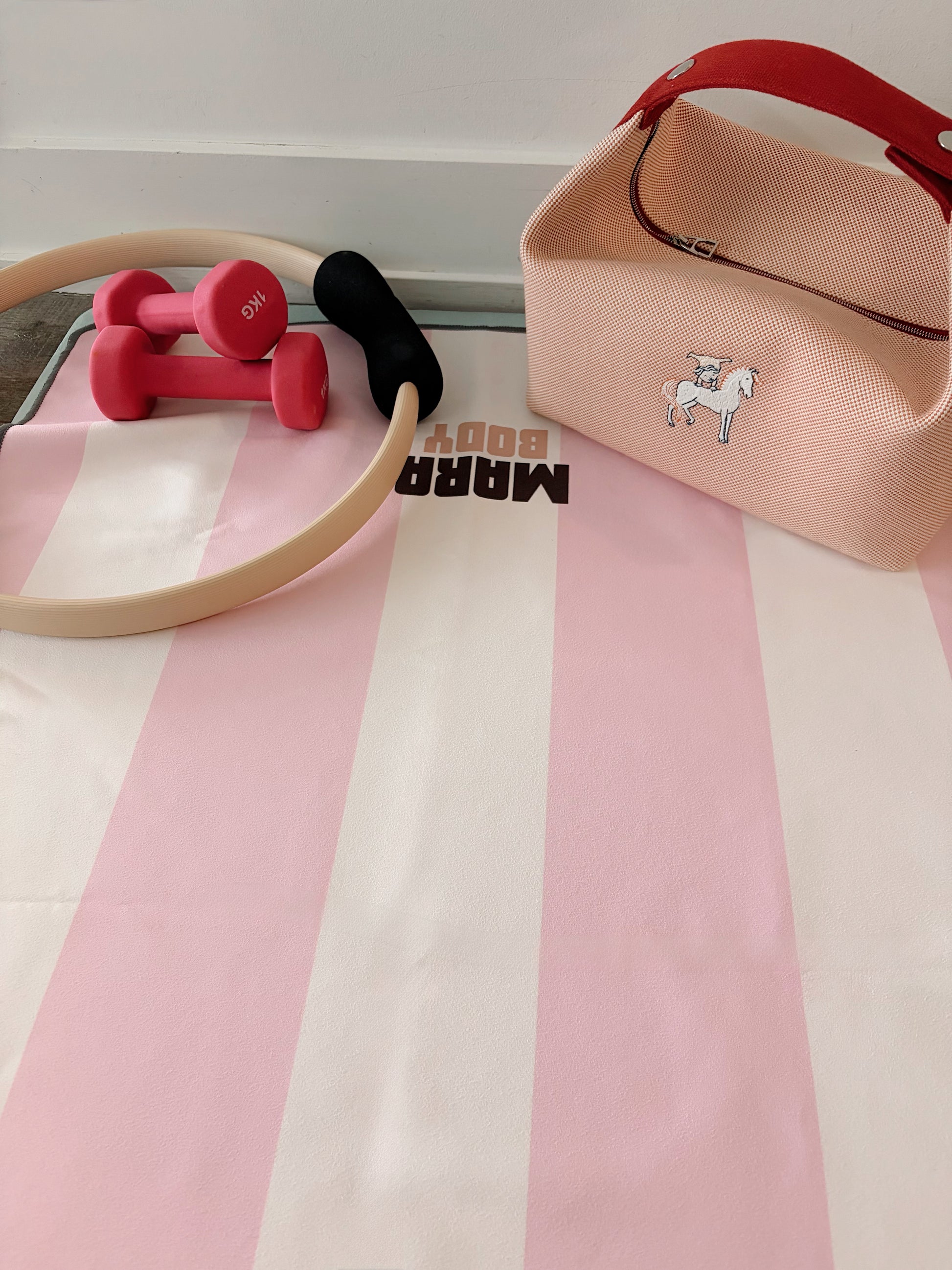 pink white striped yoga towel for hot yoga and yoga mat with pink dumbbells, pilates ring and hermes bride a brac bag