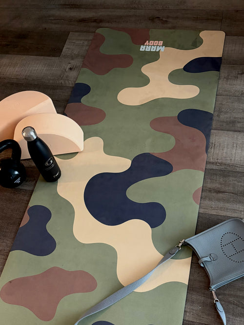 A long yoga mat with an abstract camouflage pattern in olive green, beige, brown, and navy, laid out on a dark wood floor. The mat features the brand name 'MARA BODY' printed in white near the top.
Designer yoga mat Canada, vegan suede yoga mat canada, at home workouts yoga mat, designer yoga mat, hot yoga mat canada, yoga mat for hot yoga, soft yoga mat canada, thick yoga mat canada, unisex yoga mat, yoga mat for men, yoga mat for men canada, military style yoga mat, yoga gift for him, fitness gift for him