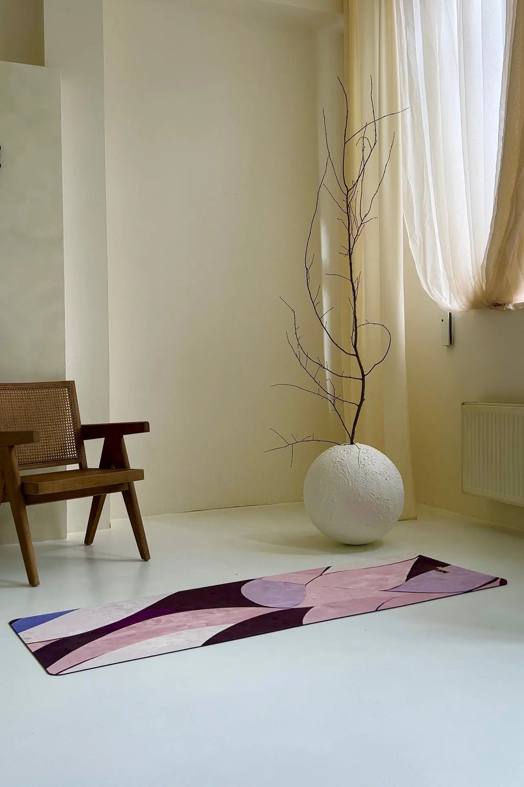 Modern room with a beautiful yoga mat, plant, and chair, home workout room decor set up.
